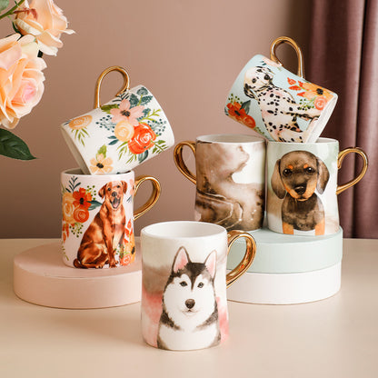 A collection of custom designed ceramic mugs with various dog breeds and floral patterns, each featuring a golden handle.